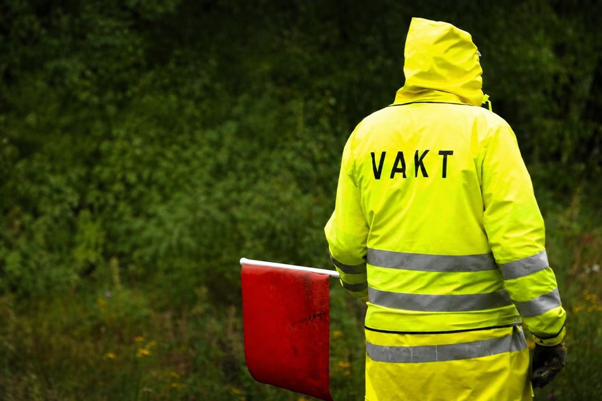Flaggvakt som dirigerar trafiken vid ett vägarbete i Göteborg